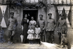 Gruppenfoto von Soldaten und Zivilisten vor einem Gebäude in einer ländlichen Umgebung