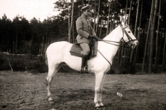 Ein Offizier der Heer sitzt auf einem weißen Pferd in einer Waldlandschaft in Deutschland während des frühen 20. Jahrhunderts