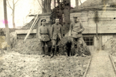 Soldaten der Heer in historischer Uniform vor einem Bunkereingang im Wald