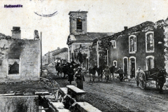 Historisches Bild von Hattonville mit Menschen und Pferdefuhrwerken in einer rauen Umgebung