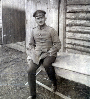 Offizier des III. Batl. IV Thüring. Inf. Regt. 72 sitzt vor einer Holzbaracke