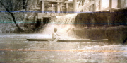 Ein Junge paddelt in einem Kanu am Wasserkraftwerk des IV. Thüringischen Infanterieregiments 72