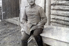 Offizier des III. Batl. IV Thüring. Inf. Regt. 72 sitzt vor einer Holzbaracke