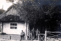 Soldaten des III. Batl. IV Thüring. Inf. Regt. 72 vor einem traditionellen Haus in ländlicher Umgebung
