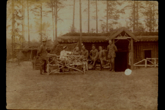 Soldaten der Heerzug 48 P.B. 11 vor einem Holzbau in einem Waldgebiet