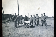 Soldaten versammeln sich um einen Tisch im Freien während eines Dienstes der Heer, S.M.W. Zug 48 P.B. 11