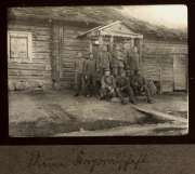 Gruppe von Soldaten vor einer holzverkleideten Hütte in Heer, Zug 48, P.B. 11, während einer militärischen Zeit