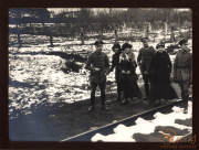 Soldaten und Zivilisten auf einem Schienenweg im Winter