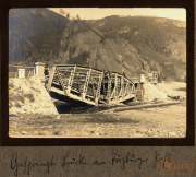 Brücke über den Fluss in Zug 48 P.B. 11, umgeben von Bergen und alter Infrastruktur