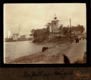 Historische Ansicht von der Hafenpromenade in Stettin mit einem markanten Turm und Vegetation