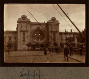 Historisches Gebäude mit Uhr und Menschen in einem städtischen Umfeld in Zug, 48 P.B. 11