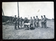 Soldaten versammeln sich um einen Tisch im Freien während eines Dienstes der Heer, S.M.W. Zug 48 P.B. 11