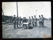 Soldaten versammeln sich um einen Tisch im Freien während eines Dienstes der Heer, S.M.W. Zug 48 P.B. 11