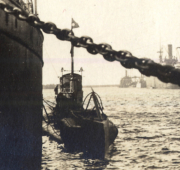 U-Boot im Hafen mit Lotsenboot und Schiffen im Hintergrund