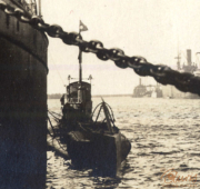 U-Boot im Hafen mit Lotsenboot und Schiffen im Hintergrund