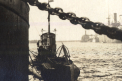 U-Boot im Hafen mit Lotsenboot und Schiffen im Hintergrund