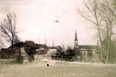 Dorfansicht mit Kirche und Pferdefuhrwerk im Ersten Weltkrieg