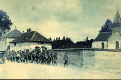 Deutsche Soldaten marschieren durch französisches Dorf mit Kirche im Ersten Weltkrieg