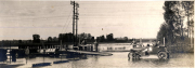 Überschwemmung mit Behelfsbrücke und Personenkraftwagen im Wasser