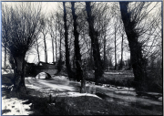 Steinbrücke über zugefrorenen Bach in Winterlandschaft bei Amagne-Lucquy