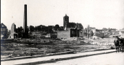 Zerstörte französische Ortschaft mit beschädigter Kirche und Industrieschornstein im Ersten Weltkrieg