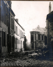 Zerstörte Dorfstraße mit beschädigten Bürgerhäusern im Ersten Weltkrieg