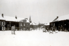 Winterlicher Marktplatz von Omont mit Ortsschild und Kirche im Hintergrund