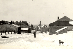 Verschneite Dorfszene mit Kirche und Steingebäuden im Winter
