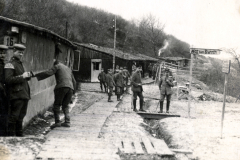 Deutsche Soldaten am Bahnhof mit Schild 'Weg zum Brunnen' in französischem Dorf
