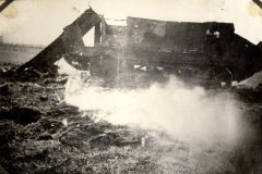 Zerstörter Panzer mit Rauchentwicklung auf französischem Schlachtfeld