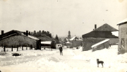 Verschneite Dorfszene mit Kirche und Steingebäuden im Winter