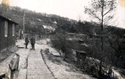 Deutsche Soldaten auf Holzsteg in Barakenlager in französischem Dorf