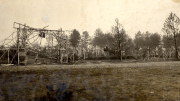 Zerstörte Eisenbahnbrücke und Soldatenfriedhof mit Holzkreuzen in französischem Dorf