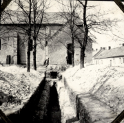 Schützengräben durch französisches Dorf mit Kirche und Wohnhäusern im Hintergrund