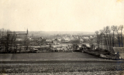 Blick auf französisches Dorf mit Kirchturm und Barakenlager im Vordergrund während des Ersten Weltkriegs