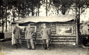 Drei deutsche Soldaten vor Holzbaracke im Waldlager des Infanterie-Regiments 53