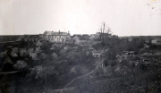 Französisches Dorf mit Kriegsschäden und mehrstöckigem Hauptgebäude auf Anhöhe