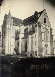Gotische Kirche mit Rundturm und beschädigtem Dach in französischem Dorf