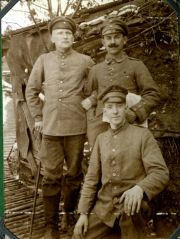 Drei deutsche Soldaten vor Unterstand mit Tarnabdeckung an der Westfront