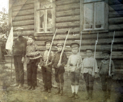 Deutsche Soldaten mit russischen Kriegsgefangenen vor Holzgebäude