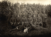 Gruppenfoto deutscher Soldaten des Infanterie-Regiments 53 mit Hund vor Hecke