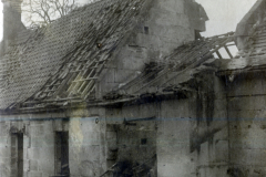 Zerstörtes Wohnhaus mit beschädigtem Dach und Schornstein im Ersten Weltkrieg