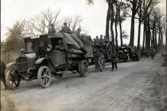 Deutscher Militärkonvoi mit Lastkraftwagen und Geschützen auf Landstraße