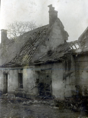 Zerstörtes Wohnhaus mit beschädigtem Dach und Schornstein im Ersten Weltkrieg