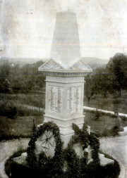 Kriegerdenkmal mit Namenslisten der Gefallenen und Trauerkränzen