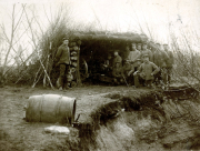 Deutsche Soldaten vor Erdbunker mit Gewehren und Ausrüstung im Ersten Weltkrieg