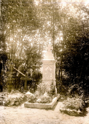 Deutsche Soldaten am Kriegerdenkmal mit Kreuz in bewaldeter Umgebung