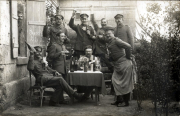 Deutsche Soldaten bei geselliger Feier vor Gebäude im Ersten Weltkrieg