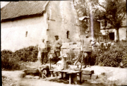 Sattler bei der Arbeit vor Dorfgebäuden