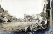 Zerstörte Dorfstraße mit Trümmern und beschädigten Gebäuden im Ersten Weltkrieg